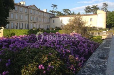 Vue aérienne d'un domaine avec jardins symétriques, bâtiments en pierre, piscine et espaces verts environnants.