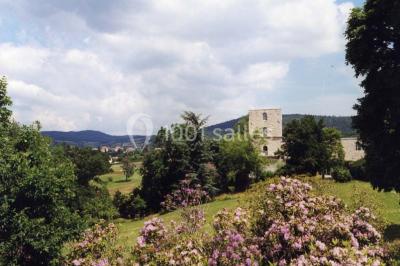Vue aérienne d'un domaine avec jardins symétriques, bâtiments en pierre, piscine et espaces verts environnants.