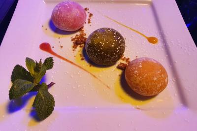 Planche de charcuterie et fromages sur une table en terrasse, avec une bouteille de vin blanc dans un seau à glace.