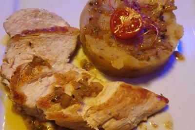 Planche de charcuterie et fromages sur une table en terrasse, avec une bouteille de vin blanc dans un seau à glace.