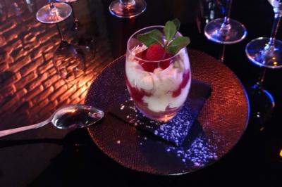 Planche de charcuterie et fromages sur une table en terrasse, avec une bouteille de vin blanc dans un seau à glace.