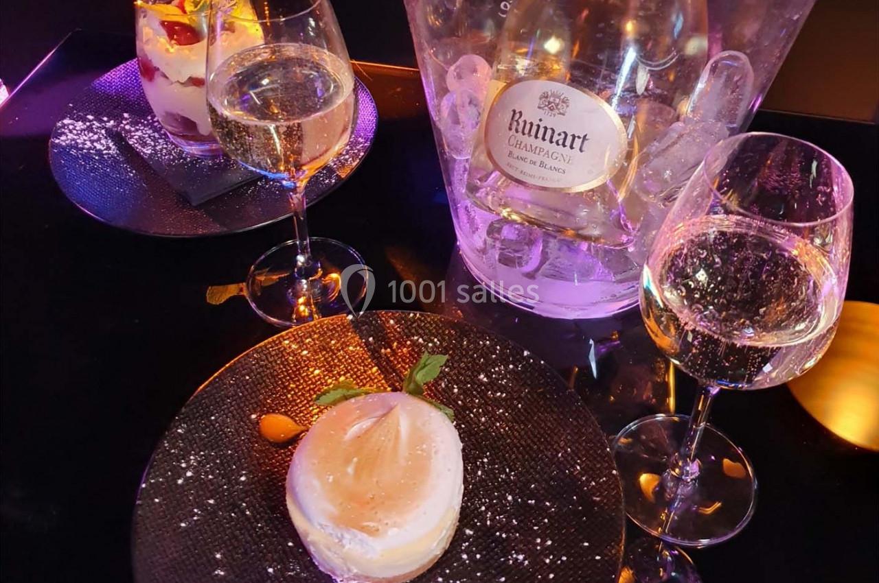 Deux desserts servis avec des verres de champagne et un seau à glace contenant une bouteille de Ruinart.