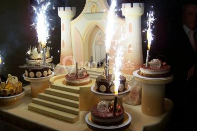 Comptoir de réception en bois avec étagères éclairées contenant des bouteilles et des verres, décoré de plantes séchées.