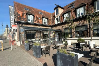 Comptoir de réception en bois avec étagères éclairées contenant des bouteilles et des verres, décoré de plantes séchées.