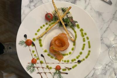 Comptoir de réception en bois avec étagères éclairées contenant des bouteilles et des verres, décoré de plantes séchées.