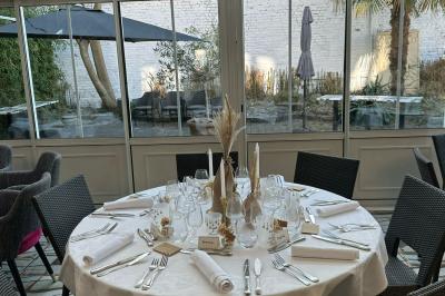 Comptoir de réception en bois avec étagères éclairées contenant des bouteilles et des verres, décoré de plantes séchées.