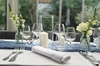 Comptoir de réception en bois avec étagères éclairées contenant des bouteilles et des verres, décoré de plantes séchées.