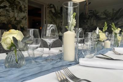 Comptoir de réception en bois avec étagères éclairées contenant des bouteilles et des verres, décoré de plantes séchées.