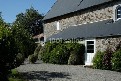 Chambre simple avec un lit double, deux lampes de chevet, des tableaux au mur et une grande fenêtre avec rideaux.