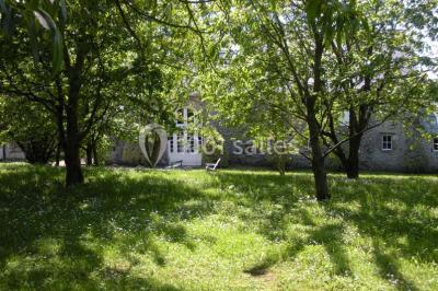 Chambre simple avec un lit double, deux lampes de chevet, des tableaux au mur et une grande fenêtre avec rideaux.