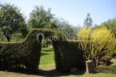 Chambre simple avec un lit double, deux lampes de chevet, des tableaux au mur et une grande fenêtre avec rideaux.