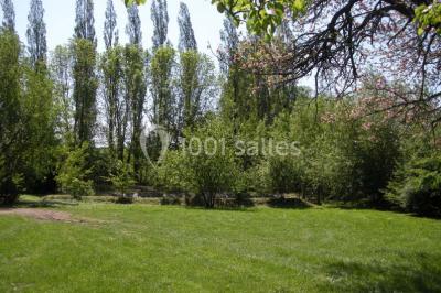 Chambre simple avec un lit double, deux lampes de chevet, des tableaux au mur et une grande fenêtre avec rideaux.