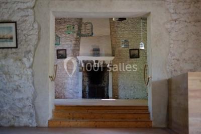 Chambre simple avec un lit double, deux lampes de chevet, des tableaux au mur et une grande fenêtre avec rideaux.