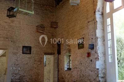 Chambre simple avec un lit double, deux lampes de chevet, des tableaux au mur et une grande fenêtre avec rideaux.