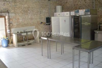 Chambre simple avec un lit double, deux lampes de chevet, des tableaux au mur et une grande fenêtre avec rideaux.