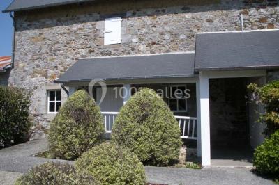 Chambre simple avec un lit double, deux lampes de chevet, des tableaux au mur et une grande fenêtre avec rideaux.