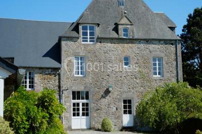Chambre simple avec un lit double, deux lampes de chevet, des tableaux au mur et une grande fenêtre avec rideaux.