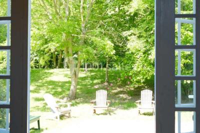 Chambre simple avec un lit double, deux lampes de chevet, des tableaux au mur et une grande fenêtre avec rideaux.