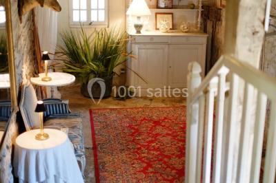 Chambre simple avec un lit double, deux lampes de chevet, des tableaux au mur et une grande fenêtre avec rideaux.