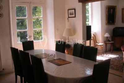 Chambre simple avec un lit double, deux lampes de chevet, des tableaux au mur et une grande fenêtre avec rideaux.