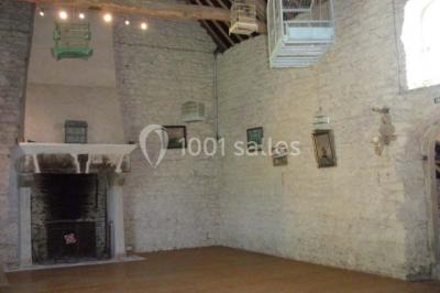 Chambre simple avec un lit double, deux lampes de chevet, des tableaux au mur et une grande fenêtre avec rideaux.