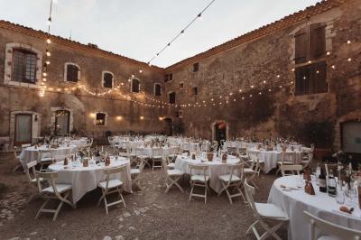 Vue sur un lac entouré de collines verdoyantes à travers une fenêtre ouverte avec des volets en bois.