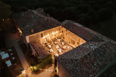 Vue sur un lac entouré de collines verdoyantes à travers une fenêtre ouverte avec des volets en bois.