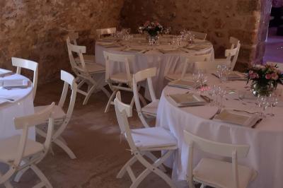 Vue sur un lac entouré de collines verdoyantes à travers une fenêtre ouverte avec des volets en bois.