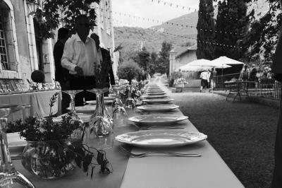 Vue sur un lac entouré de collines verdoyantes à travers une fenêtre ouverte avec des volets en bois.