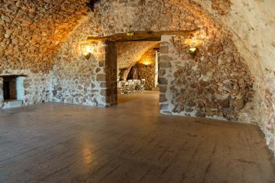 Vue sur un lac entouré de collines verdoyantes à travers une fenêtre ouverte avec des volets en bois.