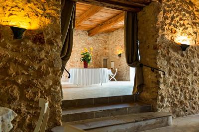 Vue sur un lac entouré de collines verdoyantes à travers une fenêtre ouverte avec des volets en bois.
