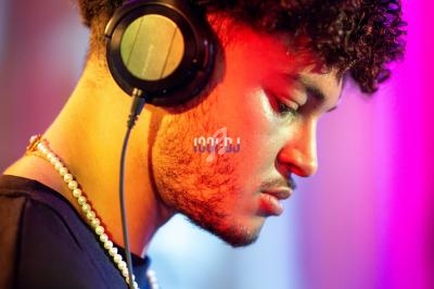 Un homme portant un casque audio, concentré, dans un environnement éclairé par des lumières colorées.