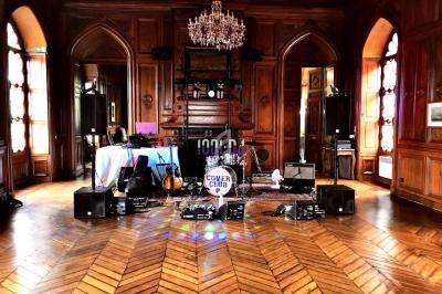 Salle en bois avec parquet, instruments de musique et matériel de sonorisation installés pour une performance.