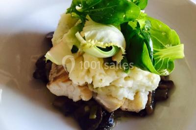 Salle décorée pour Noël avec une scène équipée de matériel audio, des décorations festives et une statue du Père Noël.