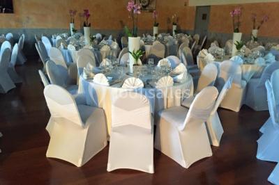 Salle décorée pour Noël avec une scène équipée de matériel audio, des décorations festives et une statue du Père Noël.