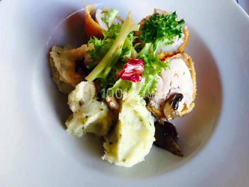 Assiette composée de roulés de volaille panés, purée de pommes de terre, champignons et salade verte.