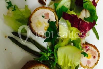 Salle décorée pour Noël avec une scène équipée de matériel audio, des décorations festives et une statue du Père Noël.