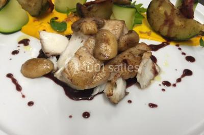 Salle décorée pour Noël avec une scène équipée de matériel audio, des décorations festives et une statue du Père Noël.