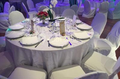 Salle décorée pour Noël avec une scène équipée de matériel audio, des décorations festives et une statue du Père Noël.