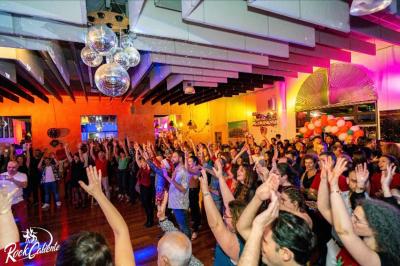 Salle décorée pour Noël avec une scène équipée de matériel audio, des décorations festives et une statue du Père Noël.