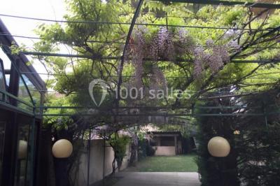 Salle décorée pour Noël avec une scène équipée de matériel audio, des décorations festives et une statue du Père Noël.