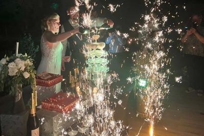 Scène décorée avec guirlandes lumineuses, plantes et une table de DJ éclairée en bleu et blanc.
