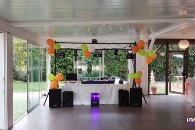 Salle sombre avec des jeux de lumières colorées et des personnes dansant sous des faisceaux laser.