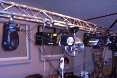 Projecteurs et équipements d'éclairage suspendus sur une structure métallique dans un espace intérieur.