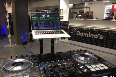 Console de DJ avec ordinateur portable en fonctionnement dans un restaurant Domino's Pizza.