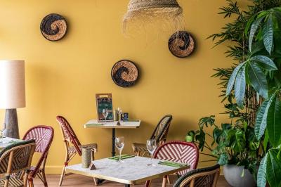 Chambre lumineuse avec un lit double, une table de chevet, une lampe et une salle de bain attenante visible en arrière-plan.