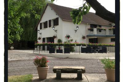 Paysage hivernal avec jardin enneigé, arbres dénudés et soleil bas illuminant la scène.