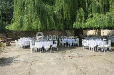 Paysage hivernal avec jardin enneigé, arbres dénudés et soleil bas illuminant la scène.