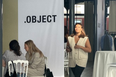 Salle de réception lumineuse avec des invités assis à des tables rondes sous un éclairage violet.