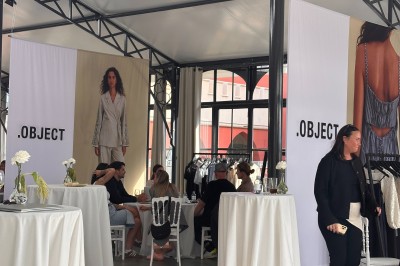 Salle de réception lumineuse avec des invités assis à des tables rondes sous un éclairage violet.